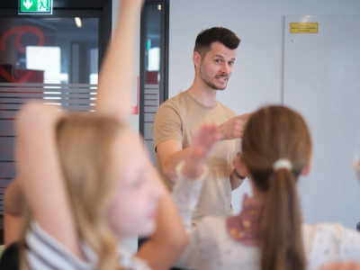 Schülerinnen und Schüler stehen vor roten Schließfächern